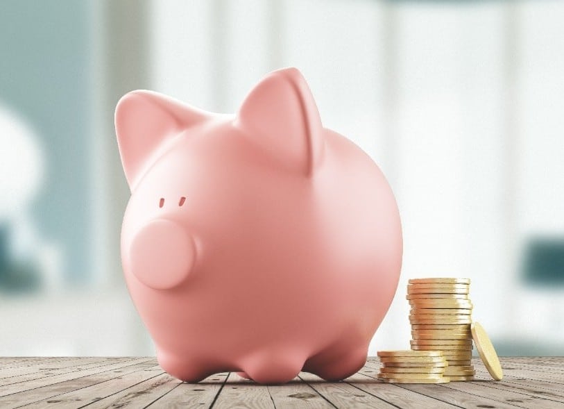 piggy bank with coins stacked next to it